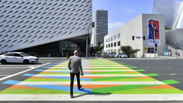 En esta foto tomada el 14 de septiembre de 2017, un hombre cruza un paso peatonal pintado por el artista venezolano Carlos Cruz-Diez frente al al Broad Museum en Los Ángeles, California.