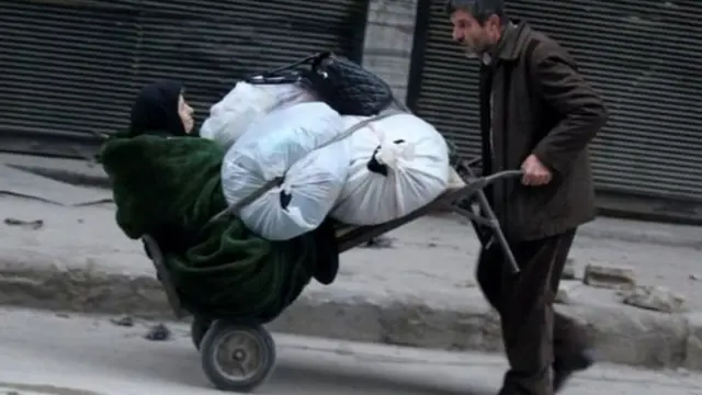 अलेप्पो में एक महिला को ले जाता व्यक्ति