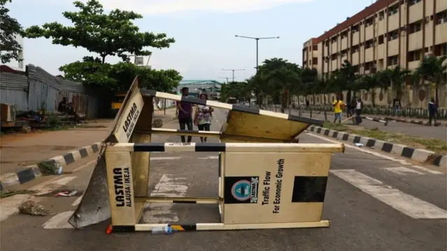People walk near a roadblock as authorities imposed a round-the-clock curfew on the Nigerian state of Lagos, in response to protests against alleged police brutality, Nigeria October 20, 2020.