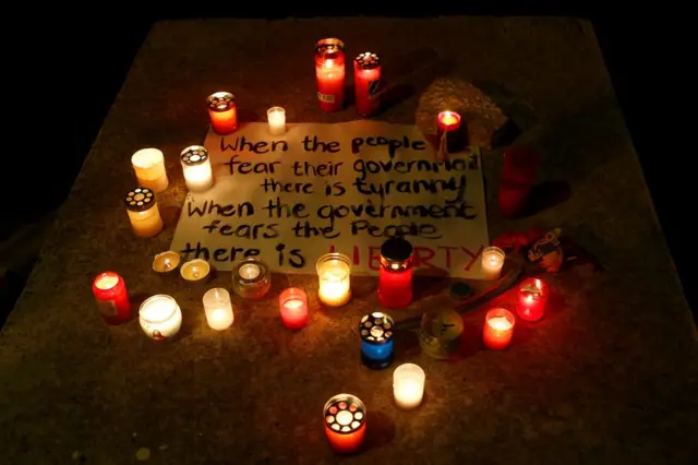 Velas rodean un cartel en el que se lee "Cuando la gente teme a su gobierno hay tiranía, cuando el gobierno teme a la gente hay libertad", colocado en memoria de Daphne Caruana Galizia, la bloguera y periodista asesinada con un coche bomba en Malta el 16 de octubre de 2017.