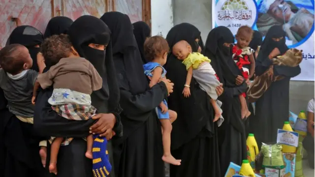 اصطف رجال ونساء يوم الخميس في جزء من المدينة لم يصل إليه العنف لتسلم مؤن من جمعيات خيرية.