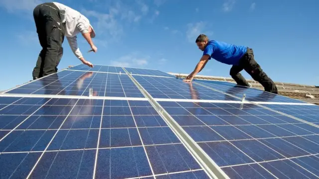 Dois homens instalando painéisjogo cassino que da dinheiroenergia solar