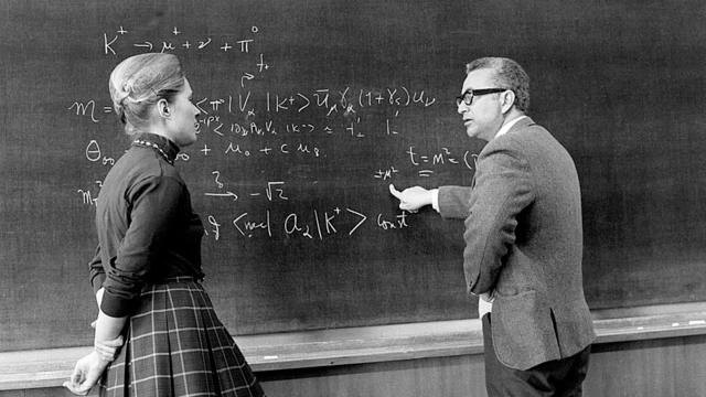 Gell-Mann discutiendo frente a un pizarrón con la física estadounidense Mary Katharine Gaillard en 1972