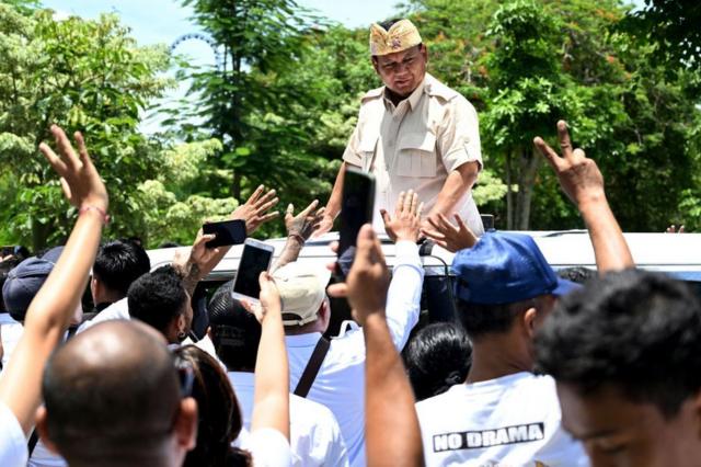 Indonesia's Defence Minister and presidential candidate Prabowo Subianto (C) greets his supporters upon in Bali on February 6, 2024