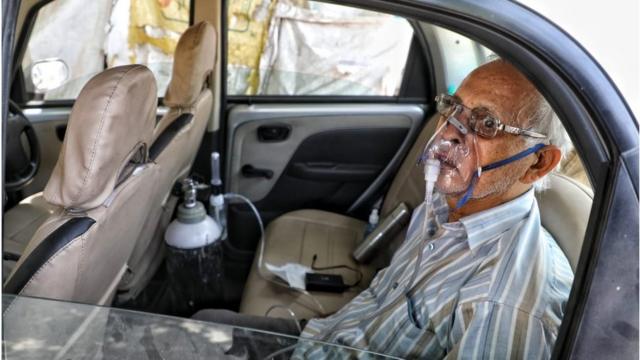 Sushil Kumar Srivastava foi fotografado sentado em seu carro, amarrado a um cilindro de oxigênio