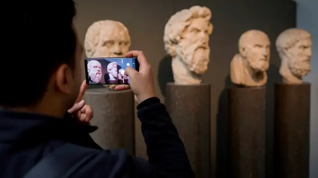 Un homme prenant en photo des bustes