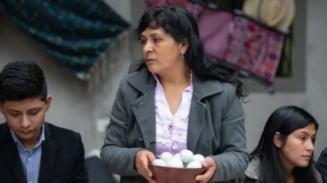 Lilia, en el centro, sostiene una cesta con huevos.