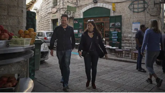 Maoz and Suraida walk through the streets