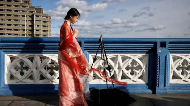 A Chinese student who calls herself Evie makes a video for her followers on Douyin, Tower Bridge in London