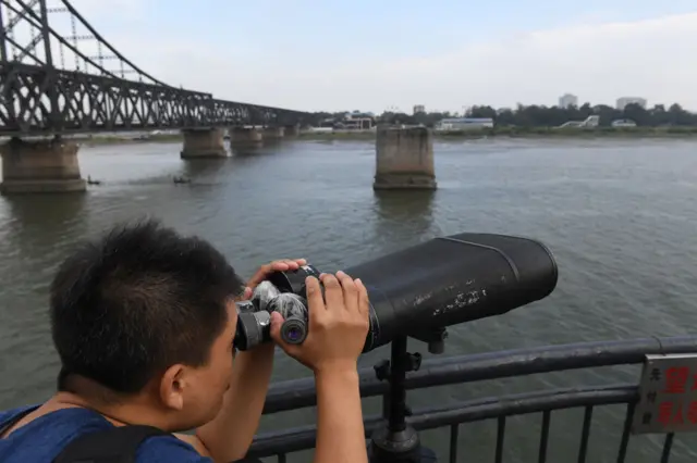 丹东鸭绿江边一名男子利用公共望远镜眺望朝鲜新义州（5/9/2017）