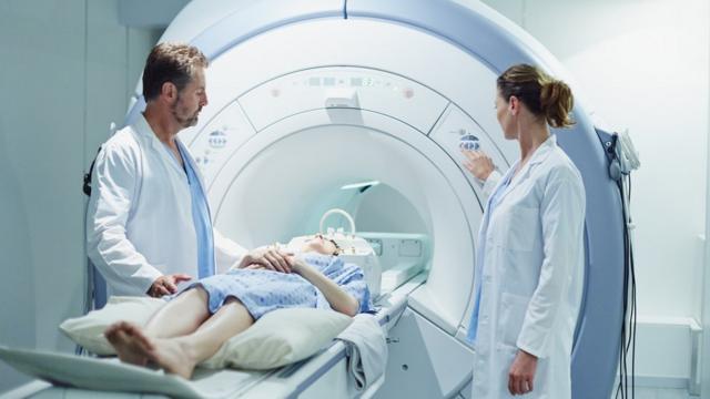 Un homme et une femme médecins préparent un patient pour une IRM.