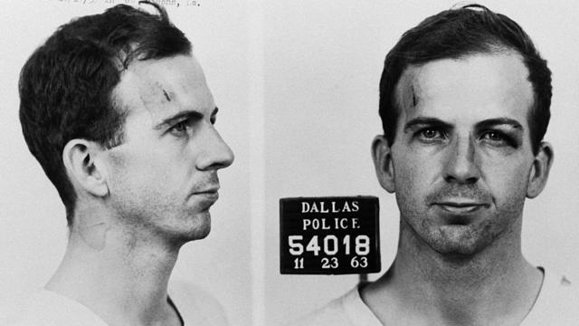 Foto de Lee Harvey Oswald ao ser fichado no departamento de polícia de Dallas acusado da morte de JFK