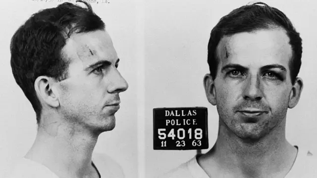 Foto de Lee Harvey Oswald ao ser fichado no departamento de polícia de Dallas acusado da morte de JFK