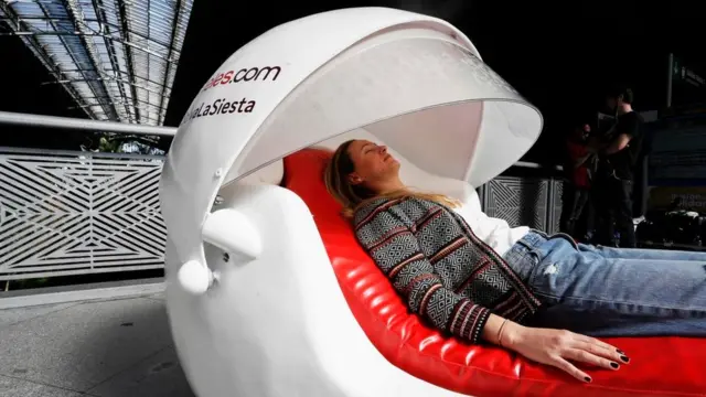 سيدة تسترخي في وحدة عامة للنوم في محطة للقطار