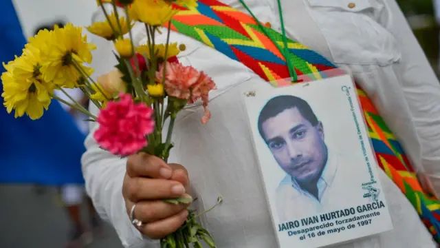 Una mujer partidaria del proceso de la paz en Colombia marcha con la foto de una víctima del conflicto