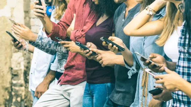 Personas jóvenes consultando sus teléfonos inteligentes