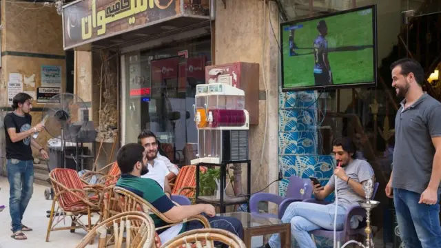 Men socialise and watch football in the area that has been recently named Little Damascus due to the high number of Syrians opening businesses there