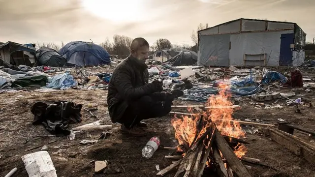 Человек у костра в палаточном лагере