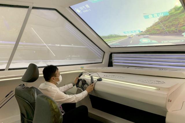 一名工作人員現場演示模擬無人駕駛。這款機器嵌入的語音識別功能將可以使乘客通過講話確定目的地。