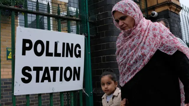 People leave a polling station in Ilford, east London, on June 8, 2017, as Britain holds a general election. As polling stations across Britain open on Thursday, opinion polls show the outcome of the general election could be a lot tighter than had been predicted when Prime Minister Theresa May announced the vote six weeks ago. / AFP PHOTO / Daniel Leal-Olivas (Photo credit should read DANIEL LEAL-OLIVAS/AFP via Getty Images)