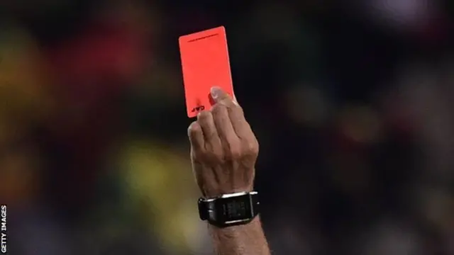 A referee showing a red card