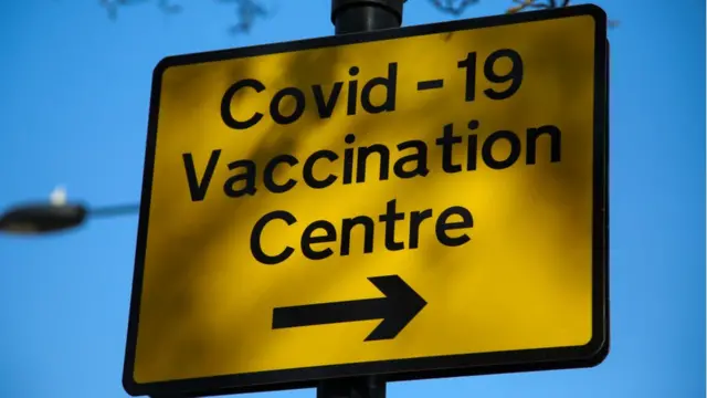 علامة تدل على اتجاه مركز تطعيم لكوفيد - 19 في لندن