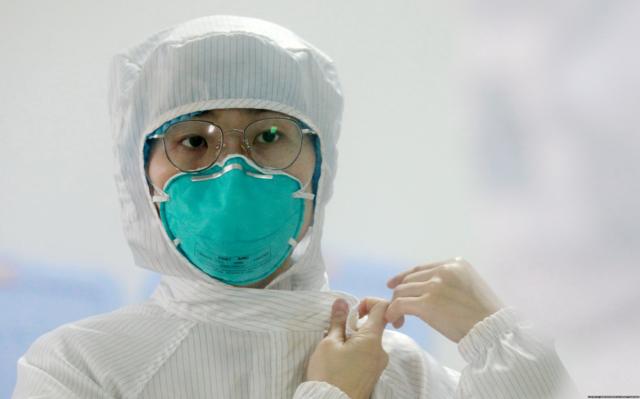 Медсестра готовится войти в палату с больными коронавирусом в провинции Янчжоу