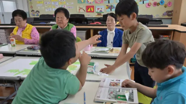 Les vieilles élèves avec leurs jeunes camarades de classe.