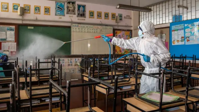 เจ้าหน้าที่ของ กทม.ในชุด PPE กำลังฉีดยาฆ่าเชื้อภายในห้องเรียนของโรงเรียนแห่งหนึ่งในกรุงเทพมหานคร