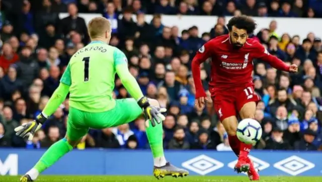 محمد صلاح مسددا الكرة باتجاه جوردان بيكفورد حارس مرمى إيفرتون