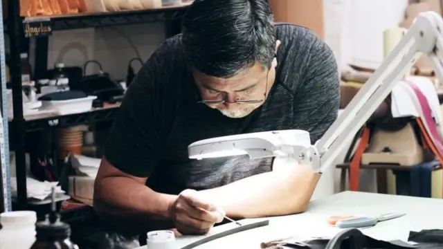 أحد المصممين في شركة "1 أتيلير" في مشغلها الكائن في حي مانهاتن