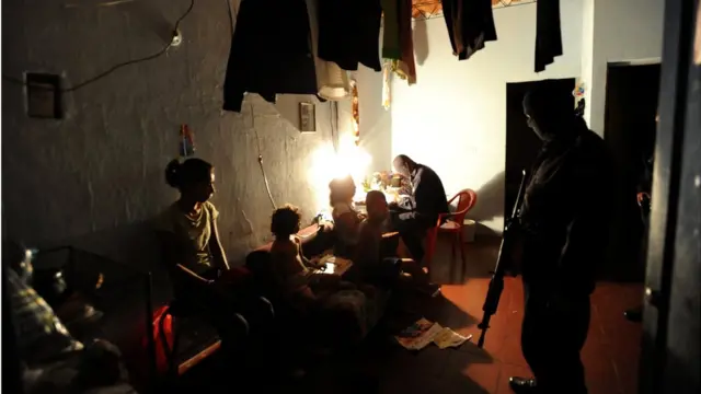 Policías revisan la casa de un sospechoso de pertenecer a las maras.