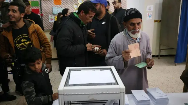 Des Algériens dans un bureau de vote