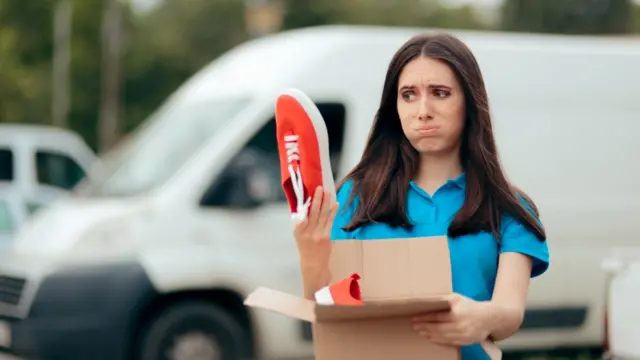 Compradora descontenta con unas zapatillas rojas.