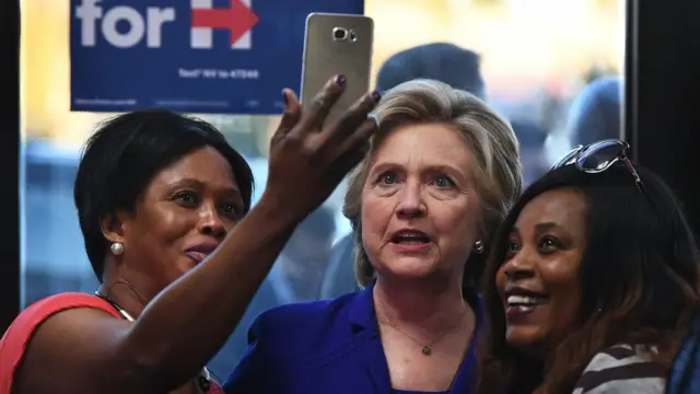 Hillary Clinton tirando selfie com eleitores.