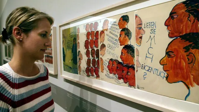 Una mujer observa pinturas de Charlotte Salomon