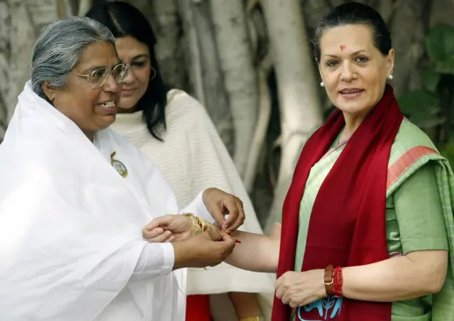 సోనియాగాంధీ చేతికి దారం కడుతున్న ఓ హిందూ సన్యాసిని