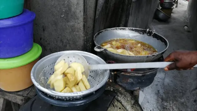 Une vendeuse en train de frire des ignames.