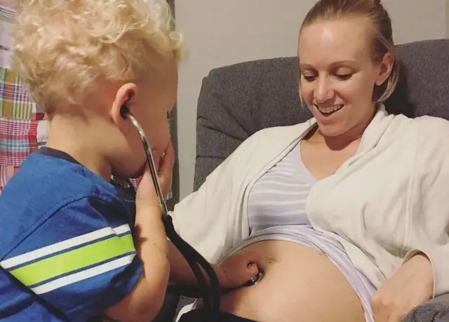 آرلن برادرش را از روی شکم مادر معاینه می‌کند