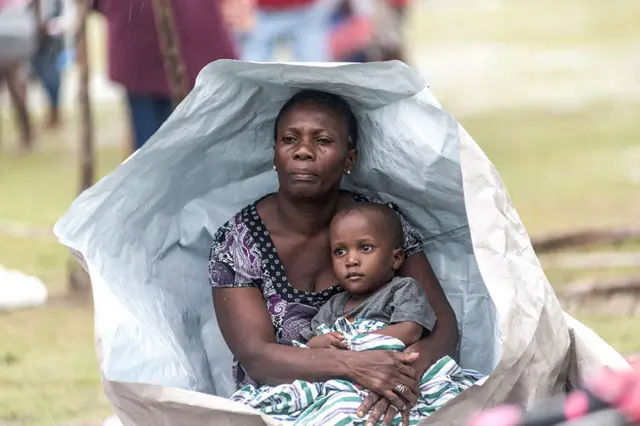 People gather after spending the night outside after facing the severe inclement weather of Tropical Storm Grace near Les Cayes, Haiti, on 17 August 2021