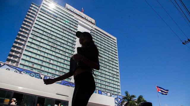 Imagem mostra mulher caminhandogreenbet tipsterfrente ao Hotel Habana Libre,greenbet tipsterHavana