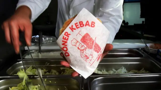 Un joven sirviendo un döner kebab