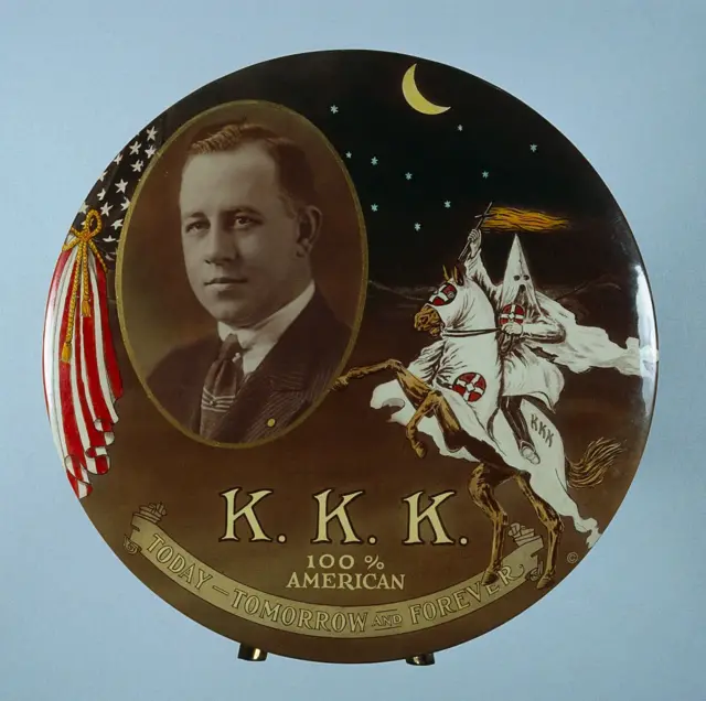 Pendedor que muestra a Hiram W. Evans, mago imperial del Ku Klux Klan (KKK), en la década de 1920, y el lema "KKK, 100 por ciento estadounidense, hoy, mañana y siempre".