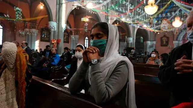 پاکستان کے شہر لاہور کے سیکرٹ ہارٹ کیتھیڈرل میں کرسمس کے دن ایک خاتون دعائیہ تقریب میں شریک ہیں۔