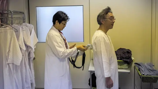 Un doctor preparara un paciente para hacerle una prueba por radiación en Fukushima.