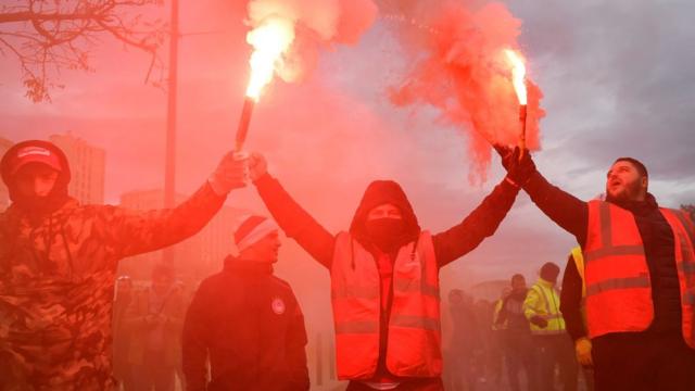 Dockers march with smoke bombs as they take part in a demonstration to protest against the pension overhauls, in Marseille, southern France, on 5 December, 2019