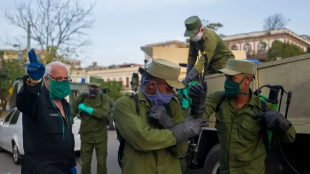 Soldados con mascarillas en La Habana yendo a desinfectar las calles.