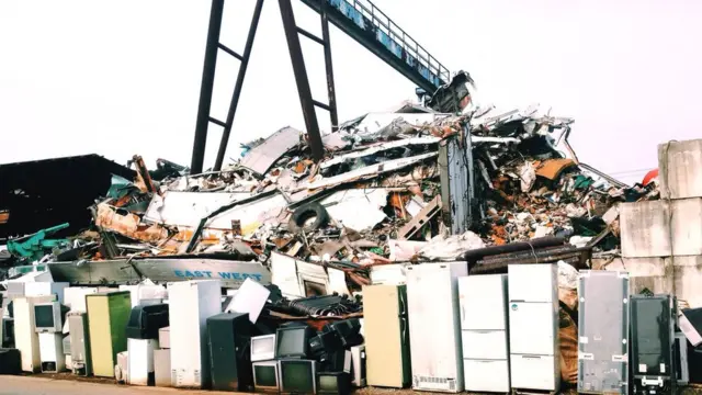 பிரிட்ஜ், டிவி, பிற மின்னணு கழிவுகளின் குவியல்.