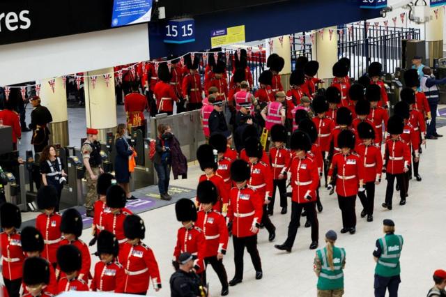 Troops in full military uniform are seen at Waterloo train station