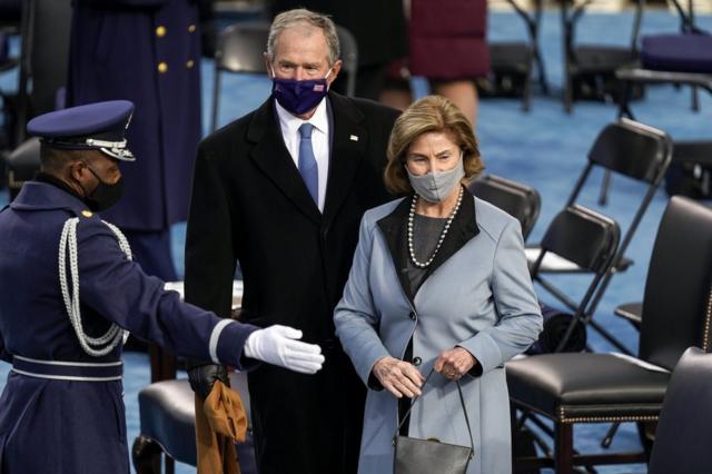 الرئيس السابق جورج دبليو بوش وزوجته لورا يتوجهان إلى المكان المخصص لهما لحضور المراسم